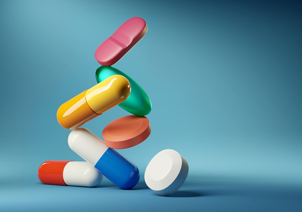 Medical balancing act. A group of medicine pills and antibiotics balacning on top of each other. 3D render illustration.